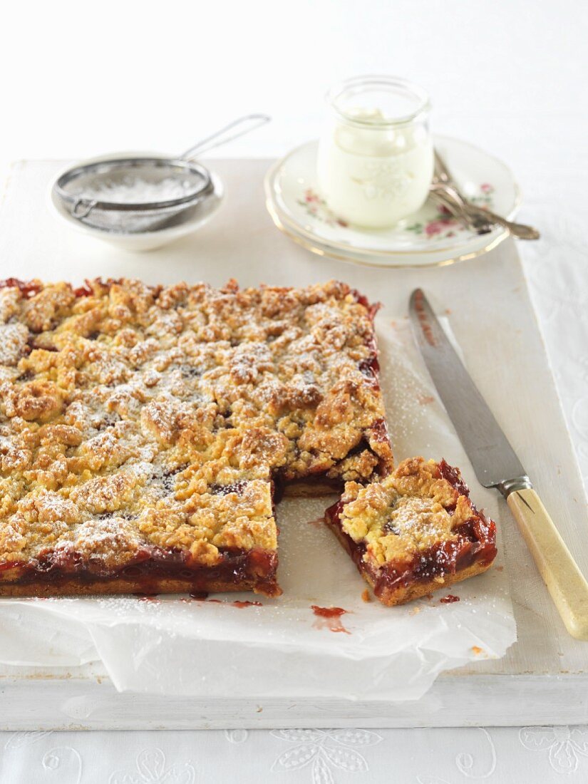 Strawberry cake dusted with icing sugar, sliced