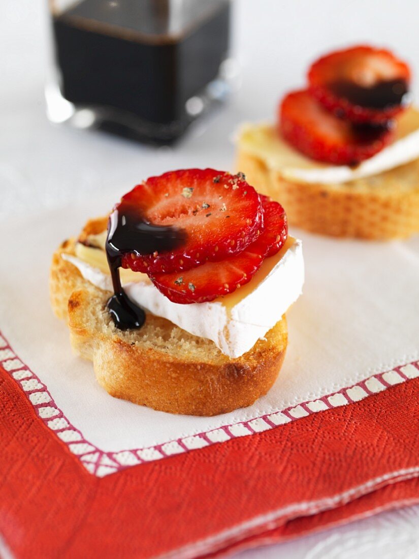 Crostini topped with strawberries, brie and balsamic cream