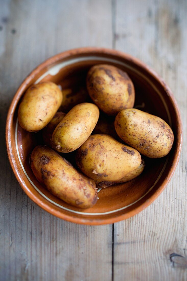 Fresh potatoes in a clay bowl