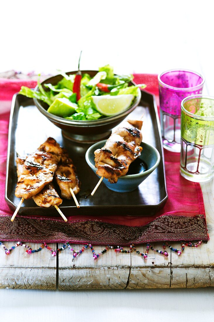 Oriental chicken sate with soy sauce and salad