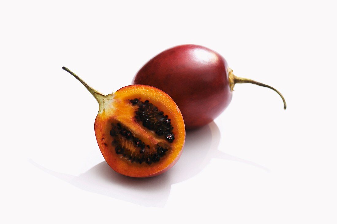 Whole tamarillo and half a tamarillo