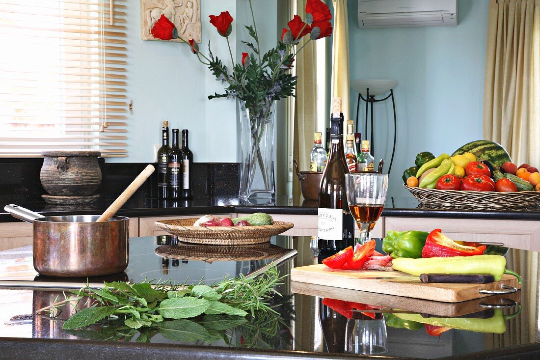 Still-life arrangement of vegetables, herbs and wine in kitchen (Villa Octavius, Lefkas, Greece)