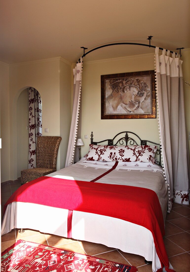 Schlafzimmer in den Farben Rot-Weiß mit Gusseisenbett und Vorhängen (Villa Octavius, Lefkas, Griechenland)