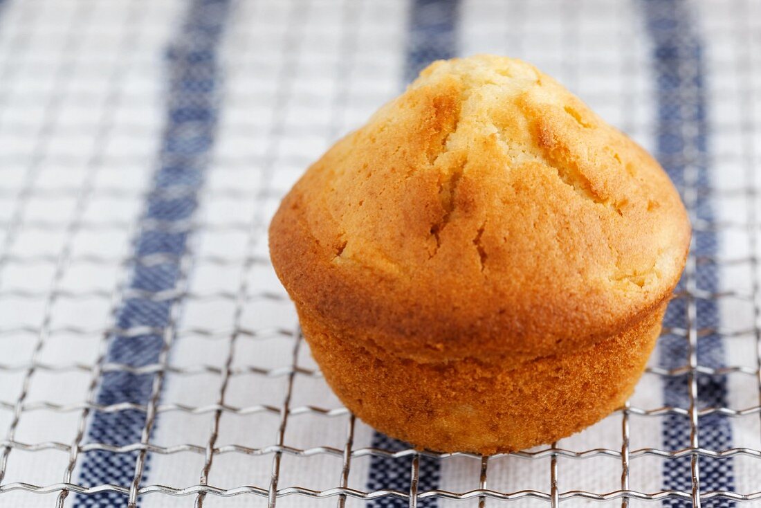 A peach muffin on a wire rack