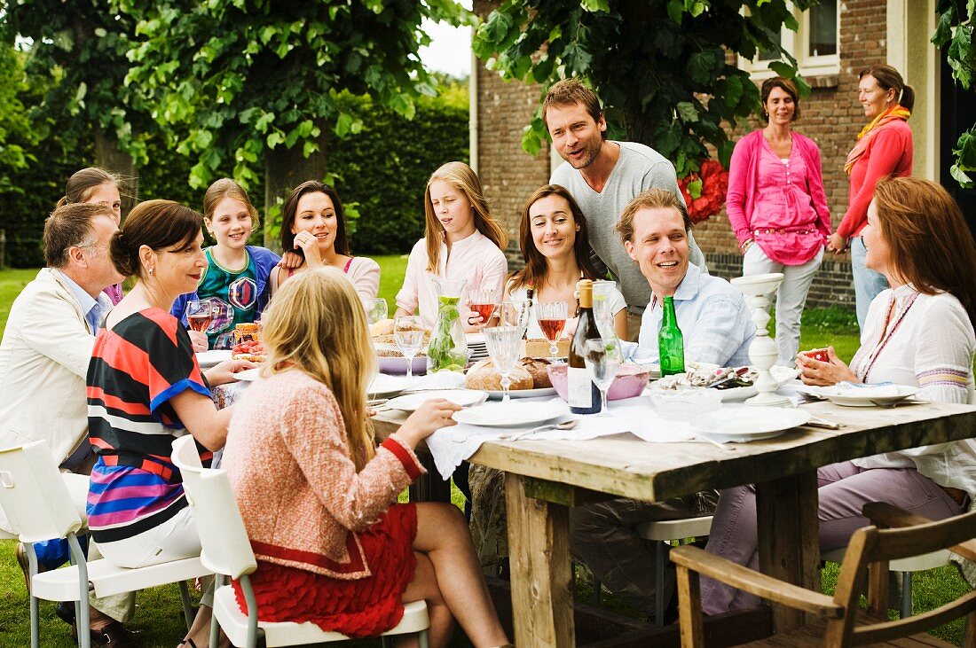 Große gedeckte Tafel mit einer Gesellschaft im Garten