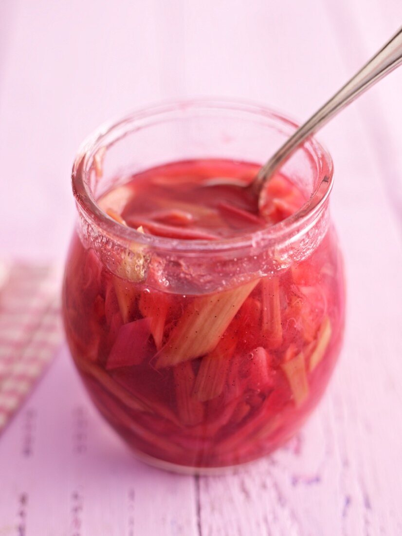 Stewed rhubarb in a jar with a spoon