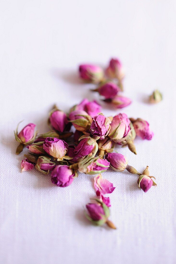 Dried rose buds on a white surface