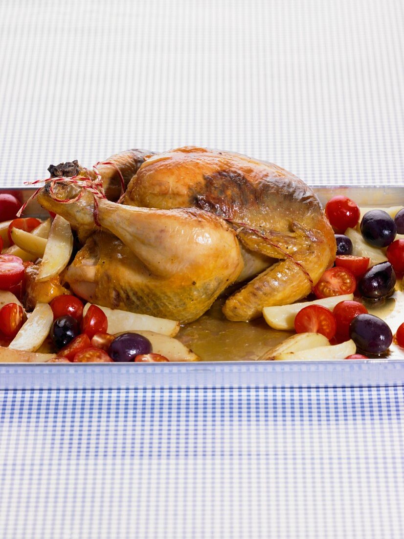 Roast chicken with potatoes, tomatoes and olives