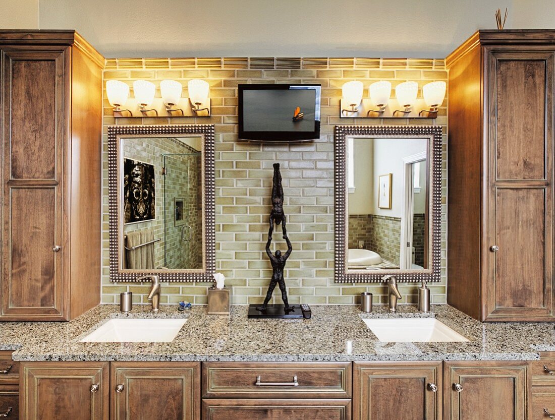 Luxuriöses Badezimmer mit Holzmöbeln und beleuchteten Spiegeln
