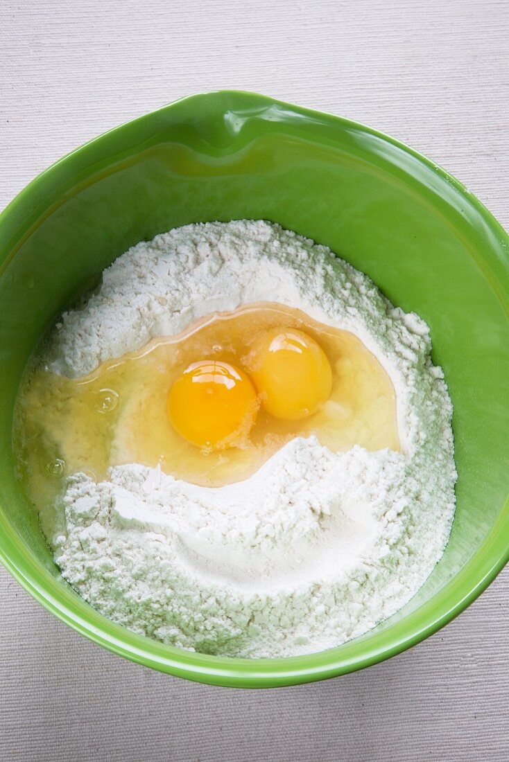 Two Eggs Cracked in a Bowl of Flour Forming a Smiley Face