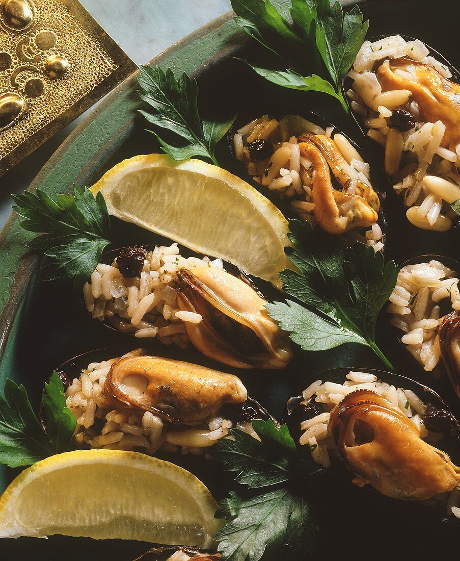 Mussels with rice and currant stuffing; lemon wedge
