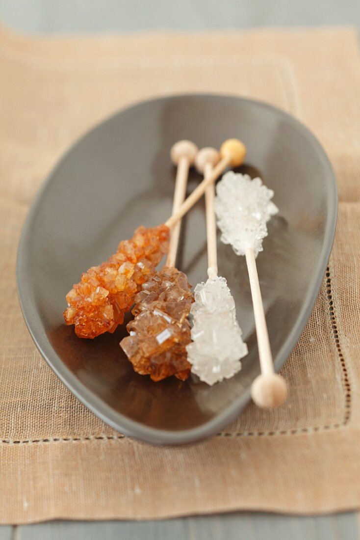 Brown and white rock sugar sticks in a bowl