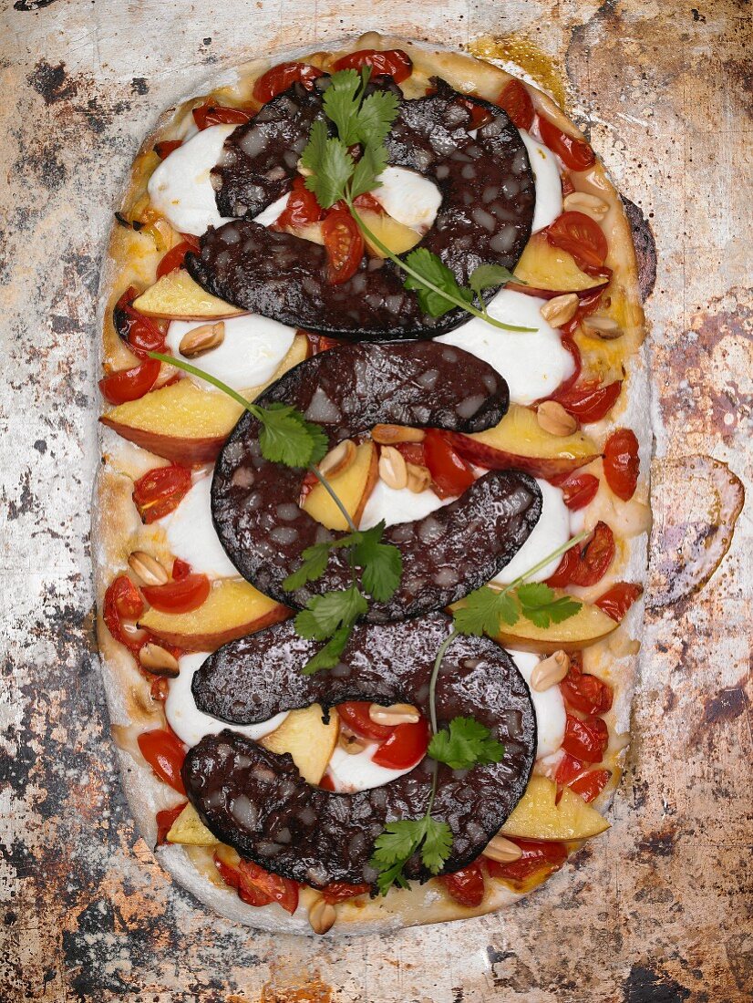 A pizza topped with black pudding, mozzarella and coriander