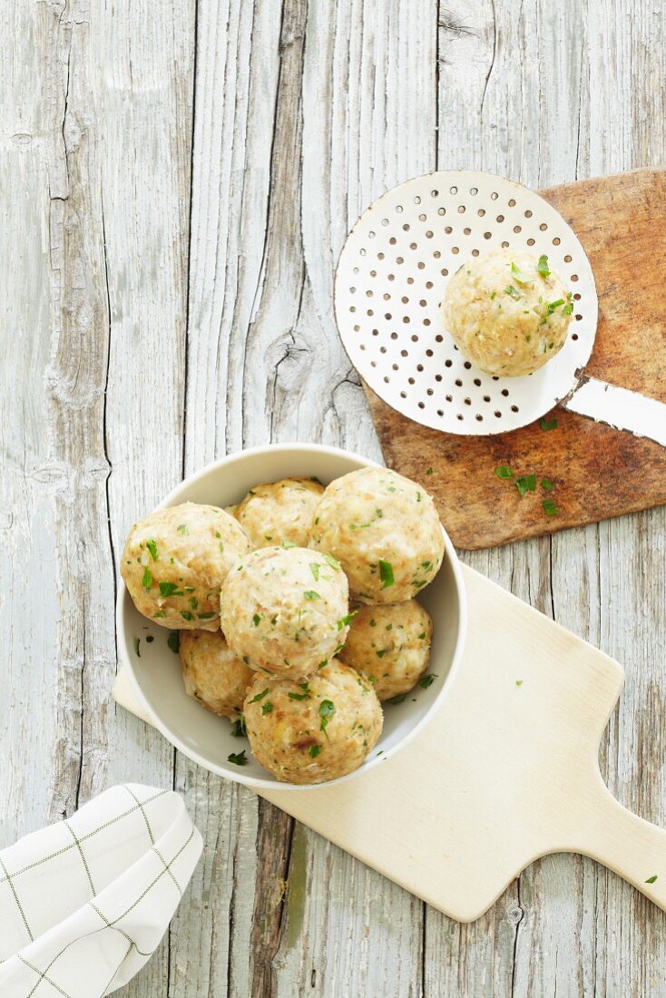 Bread dumplings in a bowl and on a draining spoon