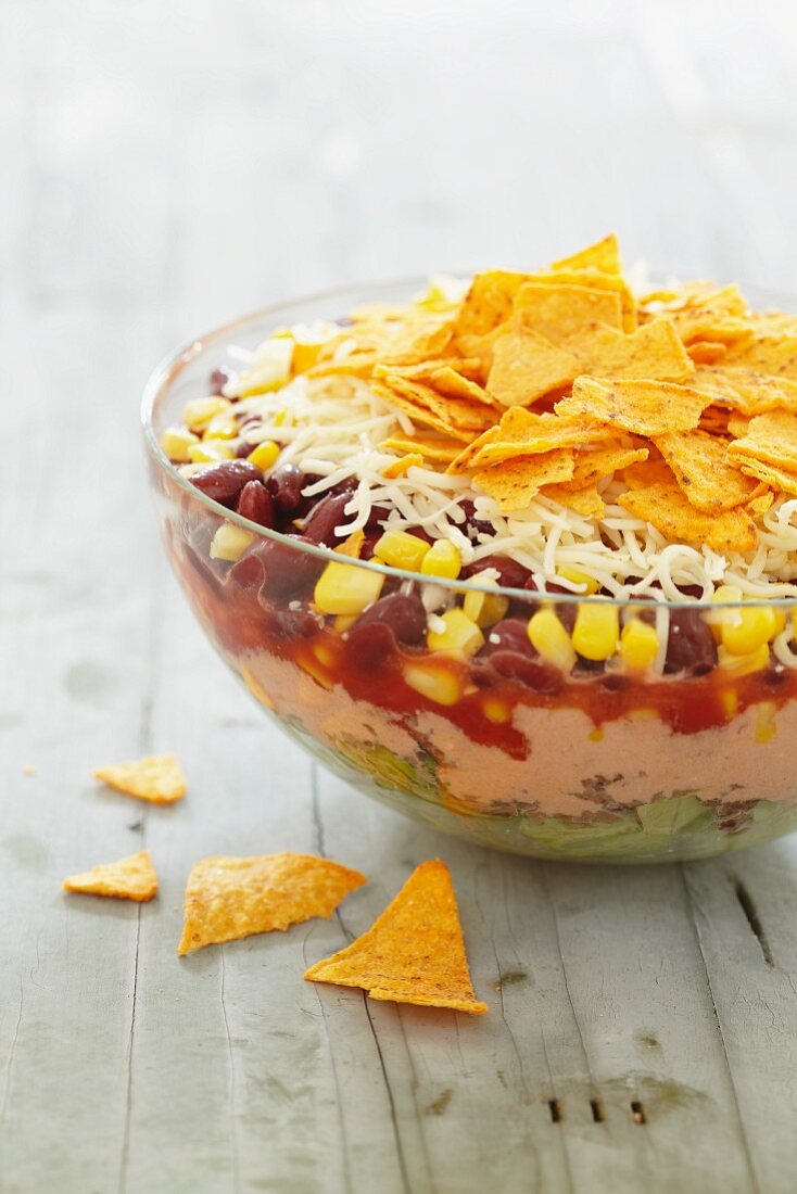 A layered salad with sweetcorn, beans and tortilla chips