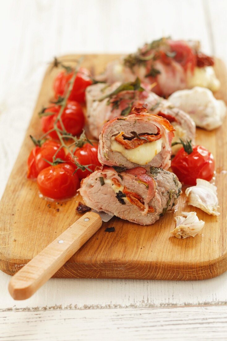 Stuffed pork fillet with mozzarella and tomatoes wrapped in bacon