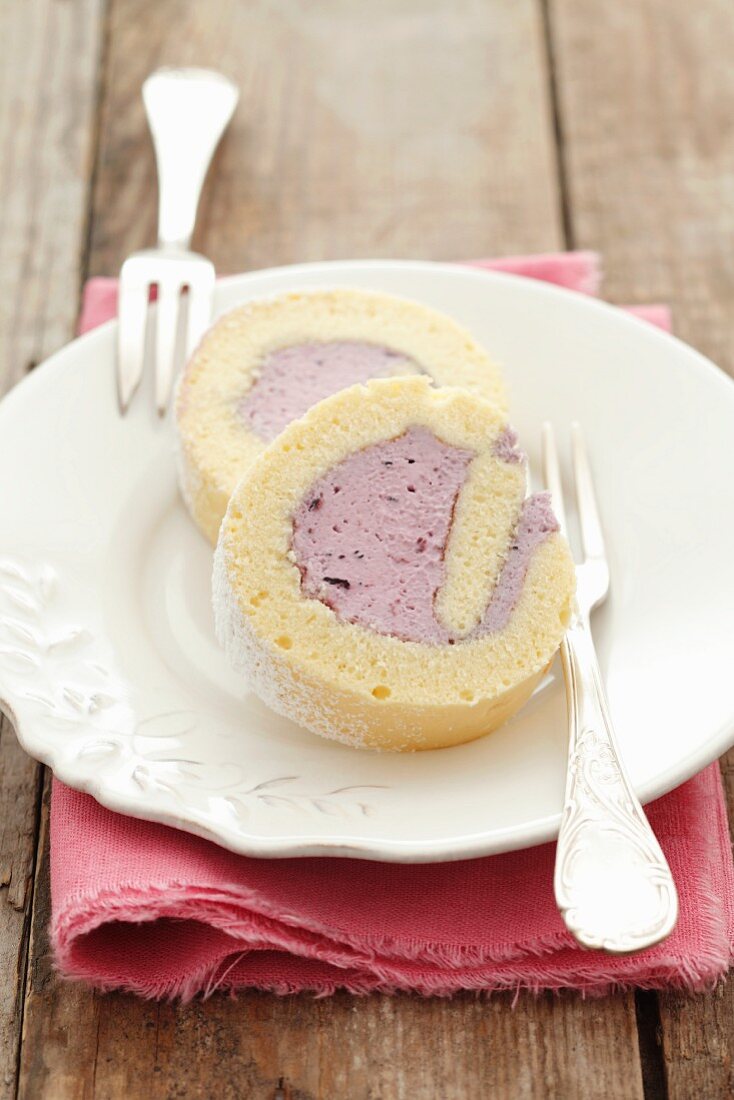 Two slices of sponge roll with blueberry cream