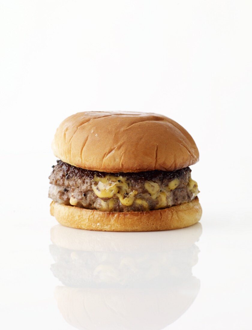 Ein Hamburger mit Käsefüllung vor weißem Hintergrund