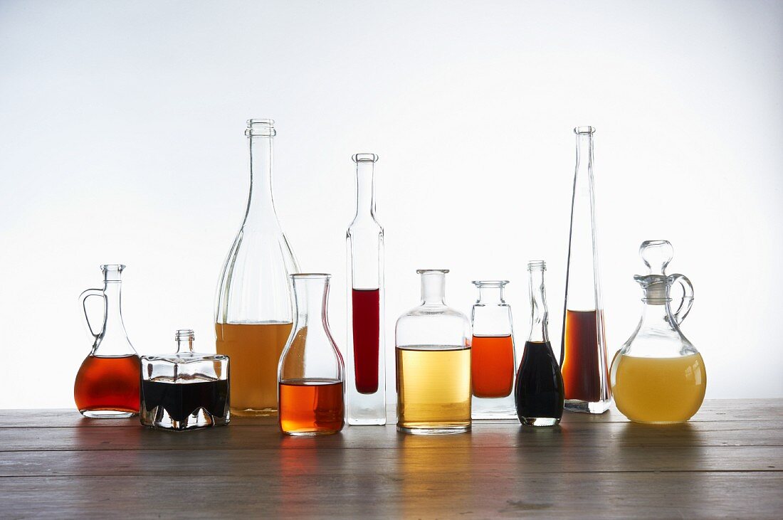 Verschiedene Essigsorten in Glassflaschen und Karaffen