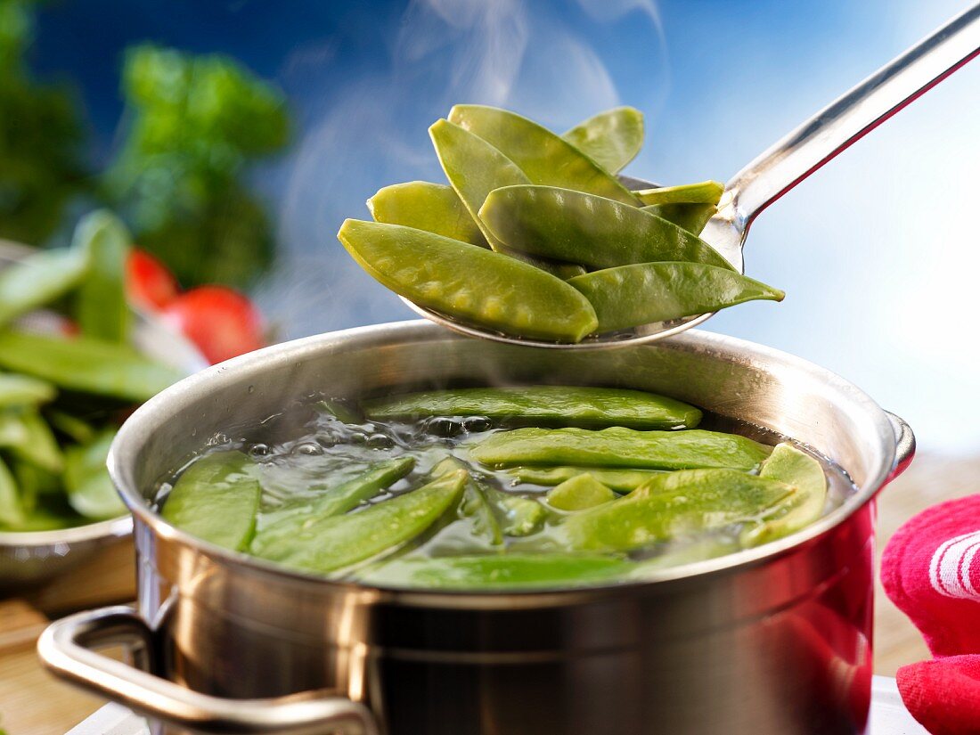 Mange tout being added to a pot of boiling water