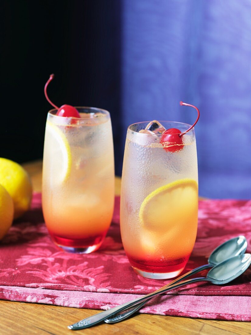 Limonade mit Kirschen und Zitronen in zwei Gläsern