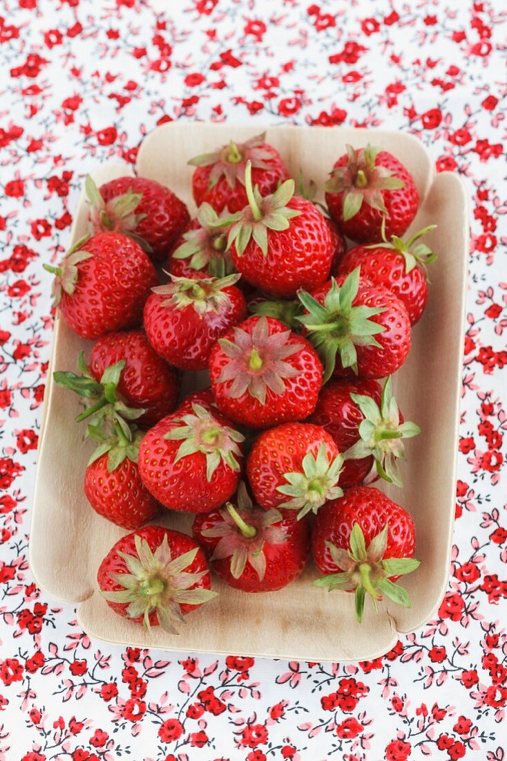 Frische Erdbeeren in Schälchen auf geblümter Tischdecke