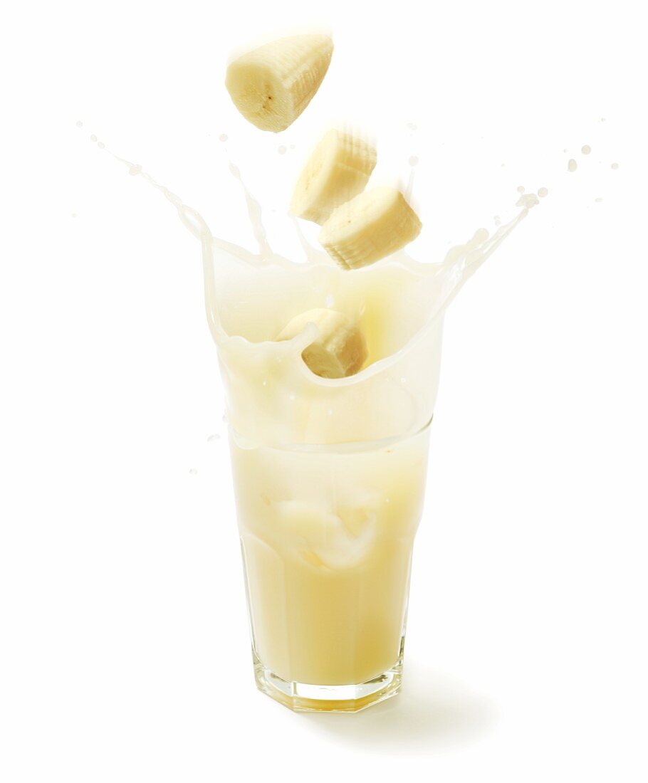Banana slices falling into a glass of banana juice