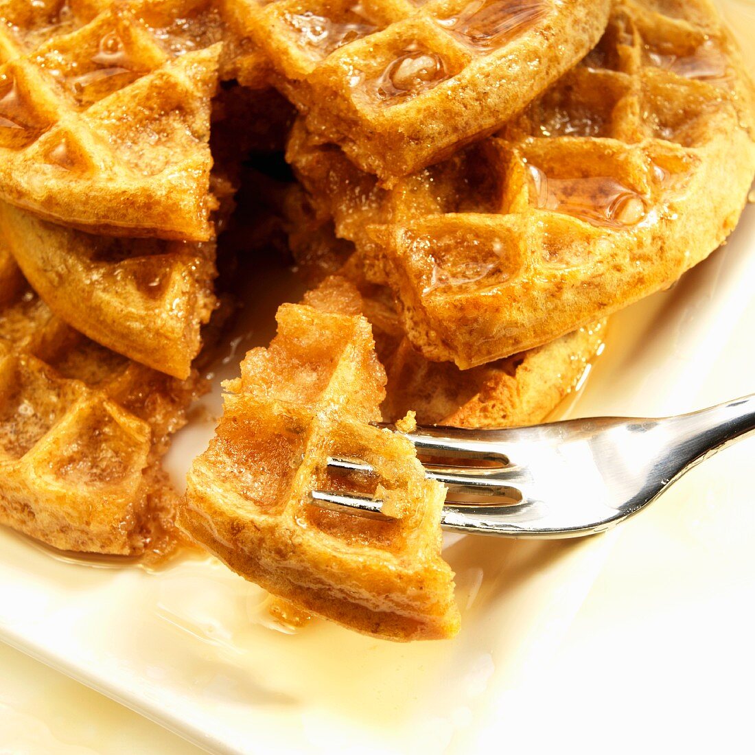 Stack of Five Grain Waffle with Organic Maple Syrup; Piece on a Fork