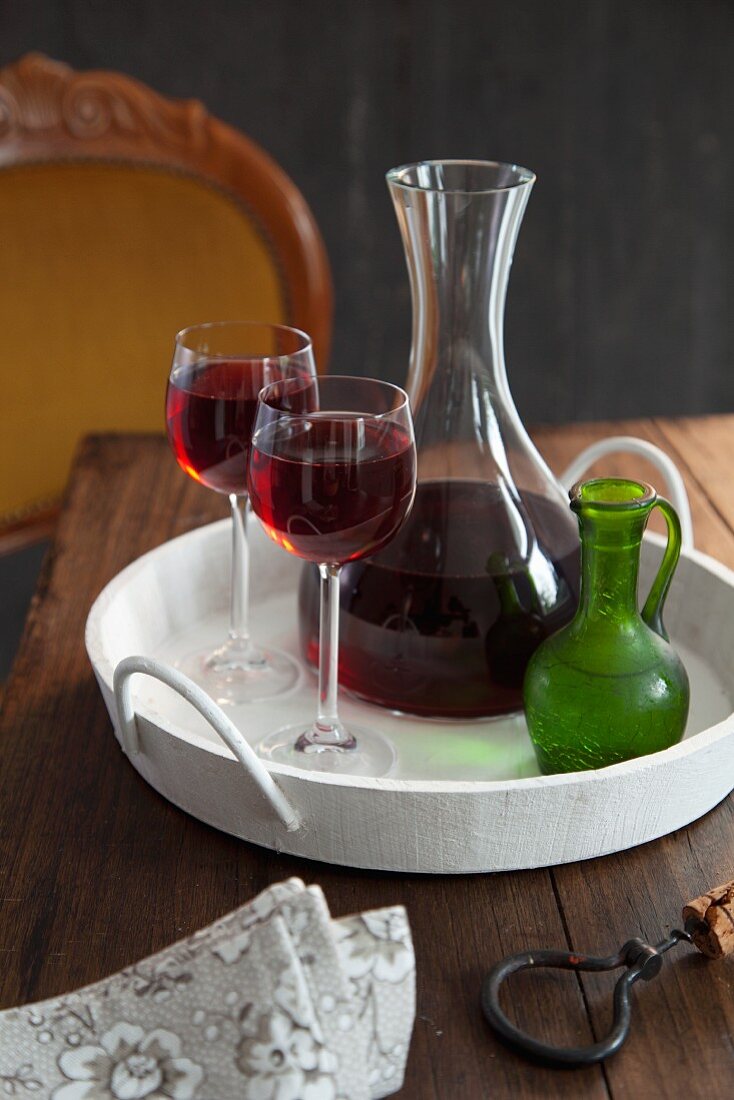 Red wine in a carafe and glass on a tray