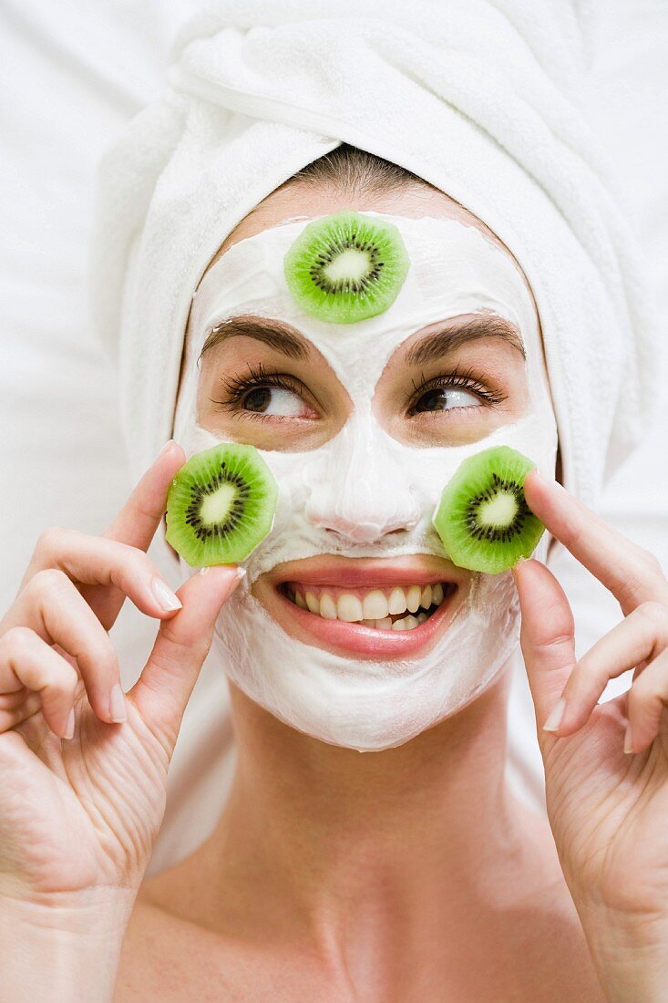 Woman with face mask and kiwi fruit