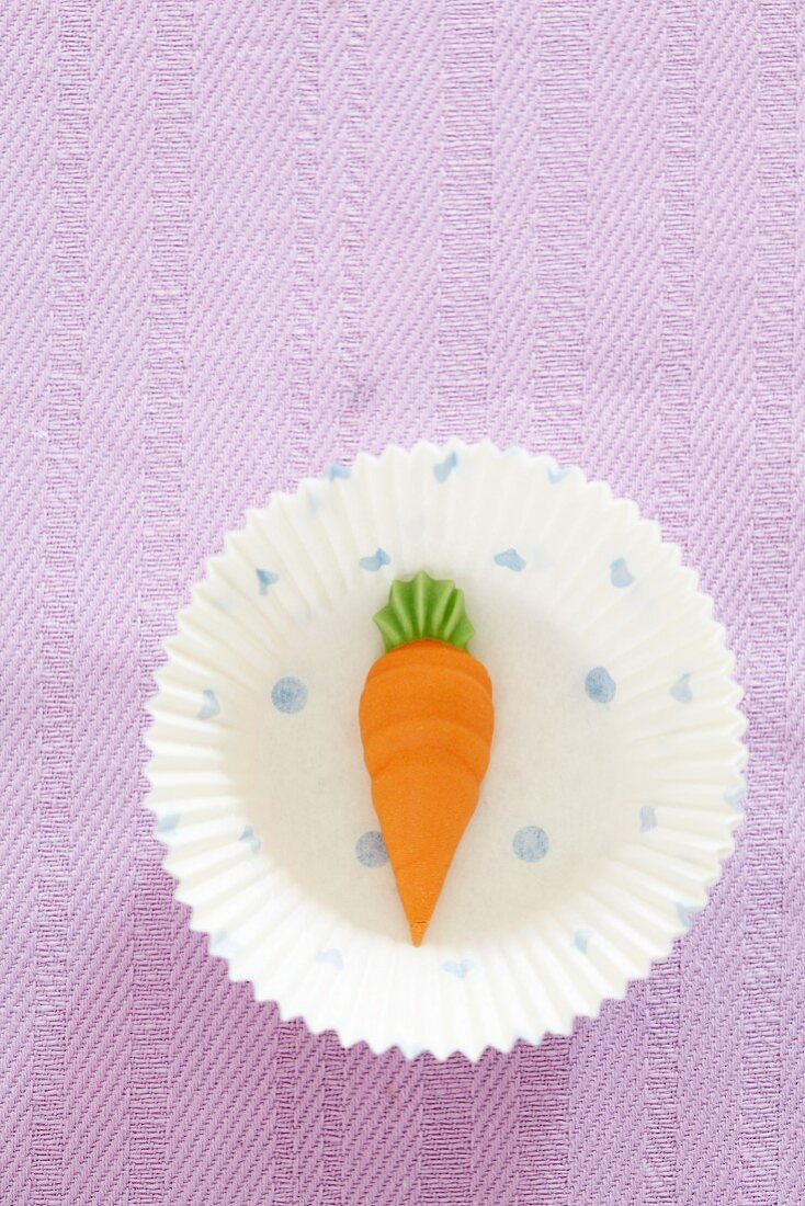 A decorative carrot in a paper case