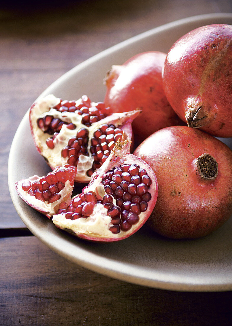 Fresh pomegranates, whole and sliced open