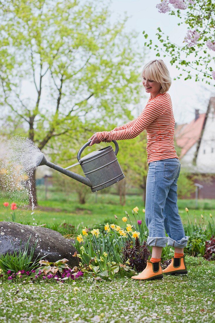 woman watering garden flowers