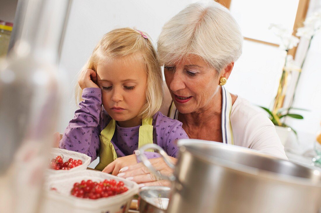 Großmutter und Enkelin kochen Marmelade