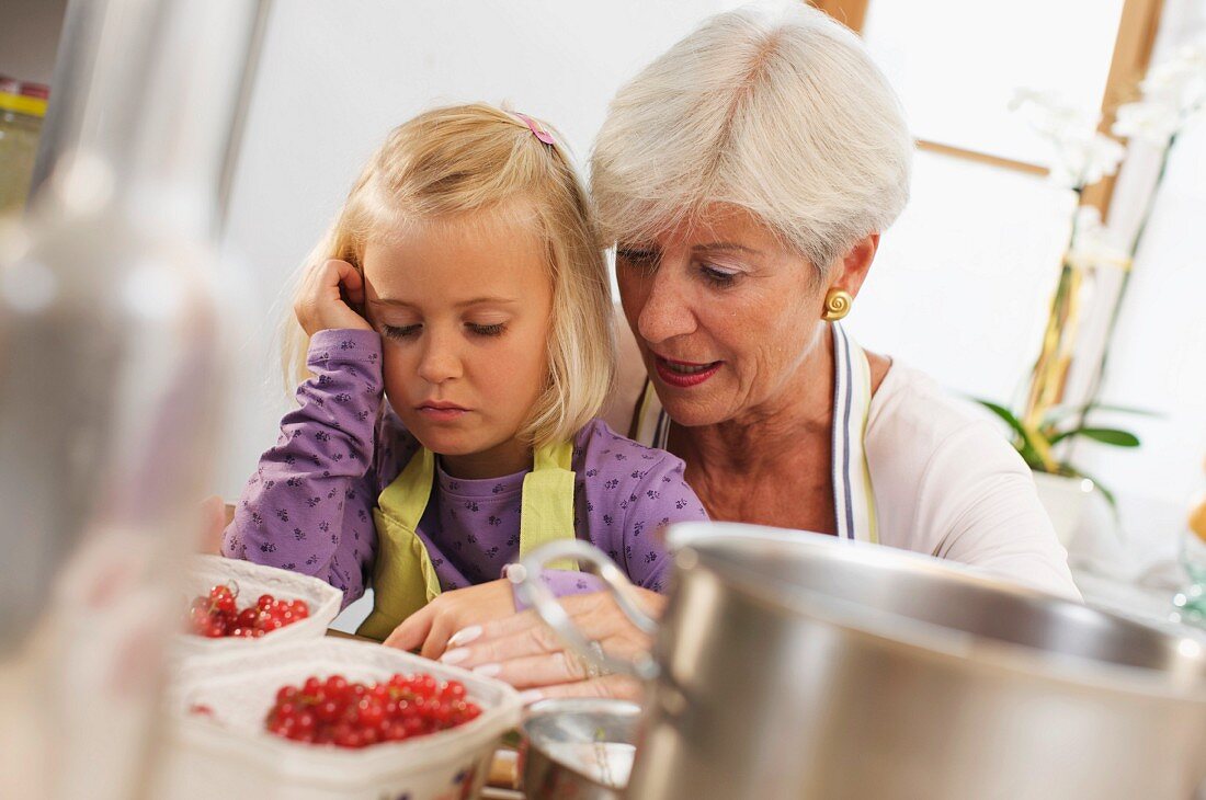 girl with grandmother cooking jam