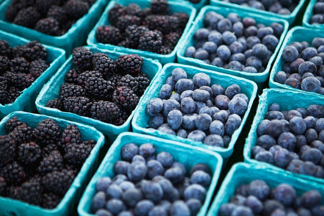 Baskets of Freshly Picked Blueberries and Blackberries at a Farmers Market