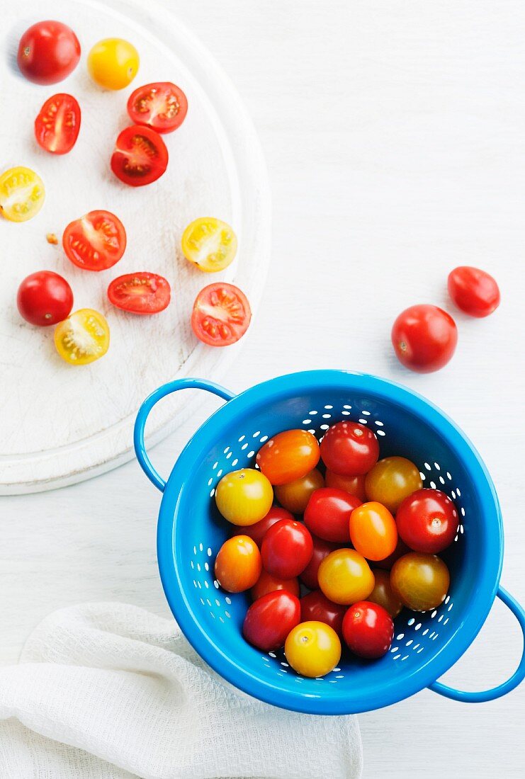 Red and yellow tomatoes in a blue colander