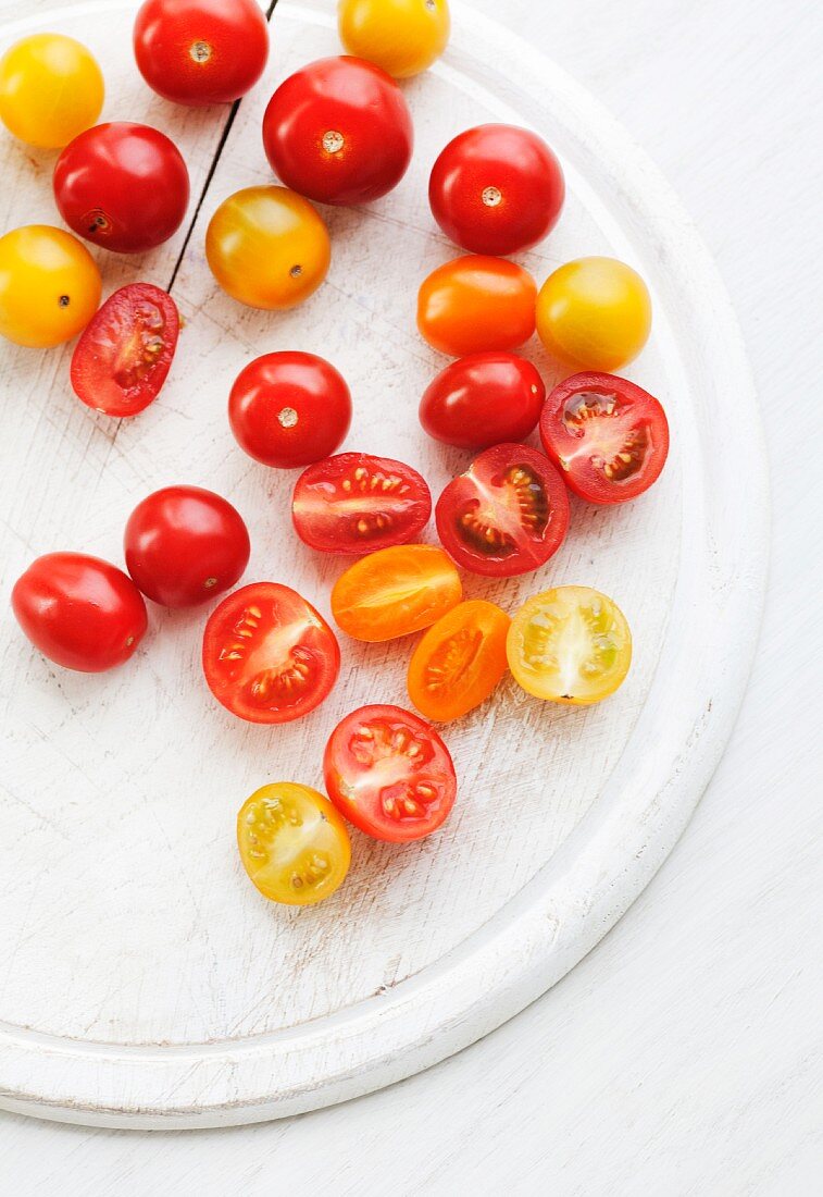 Whole and halved red and yellow tomatoes