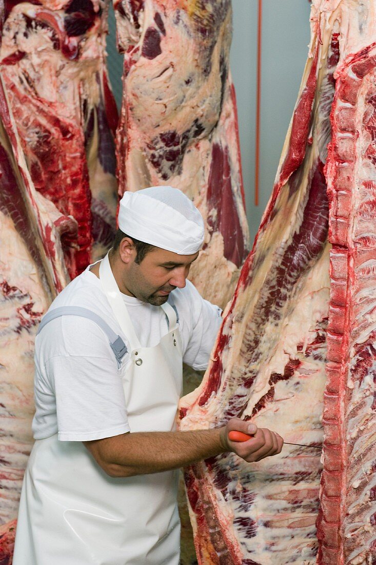 Butcher working on half a cow.