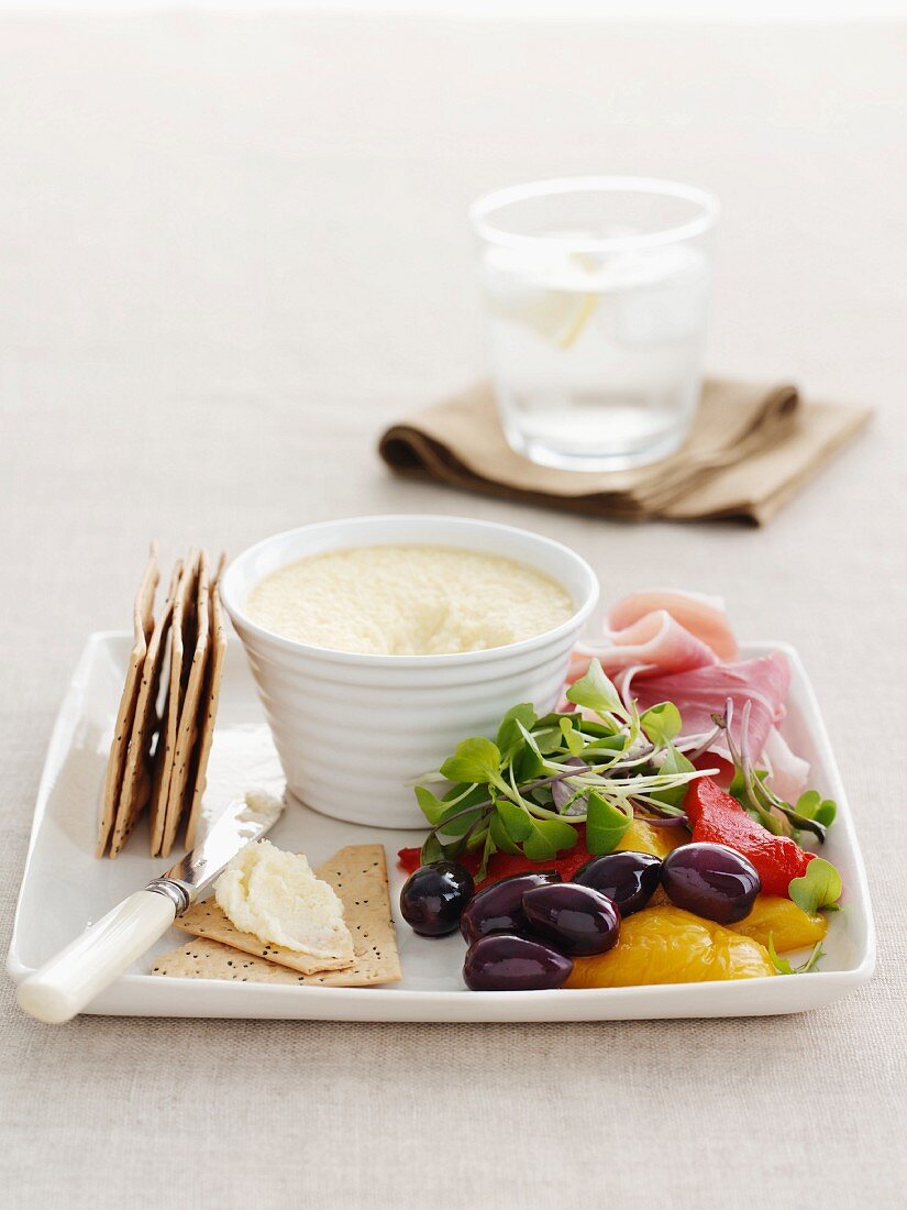 Paprika, Oliven, Schinken & Cracker mit Dip auf Servierplatte