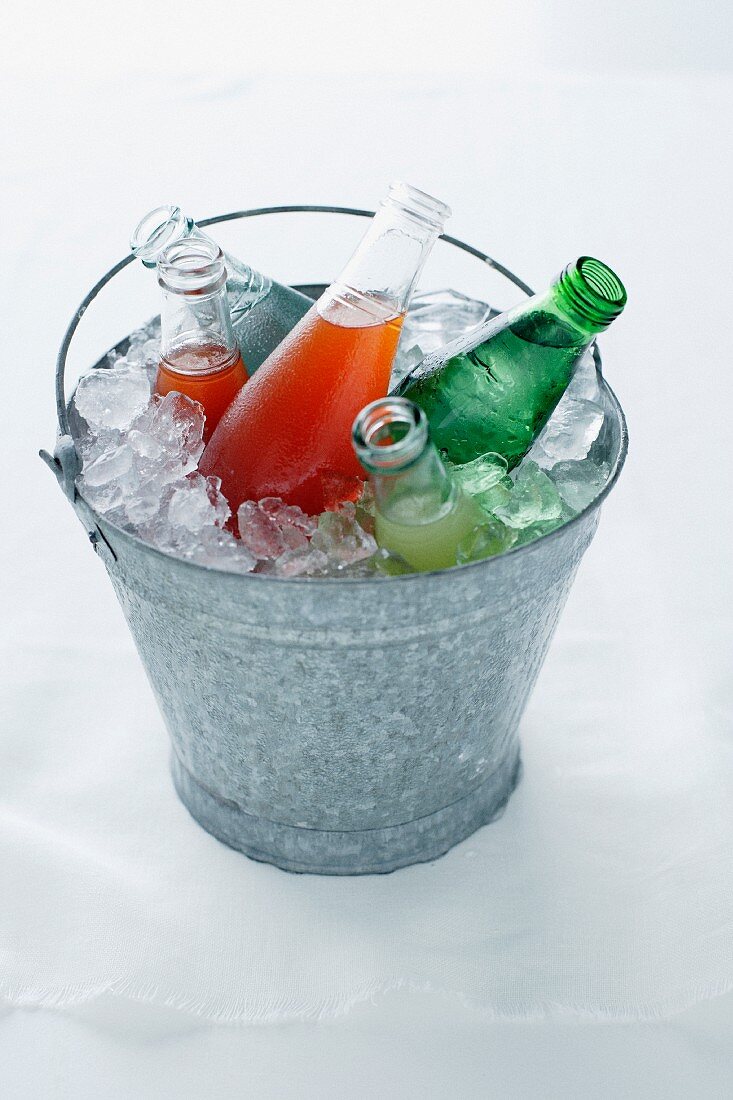 Beverage bottles in a pail with ice cubes