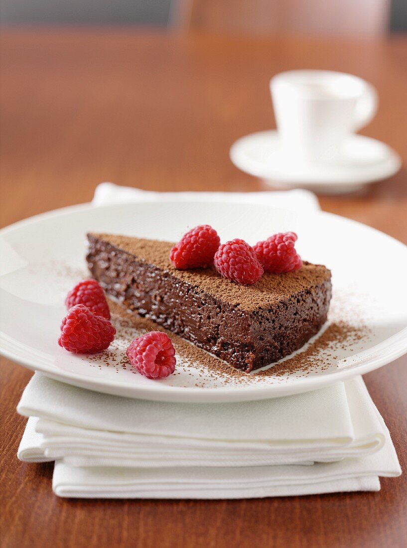 A slice of chocolate cake with fresh raspberries