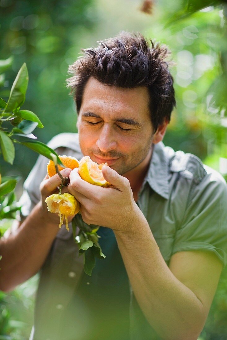 Man smelling at orange