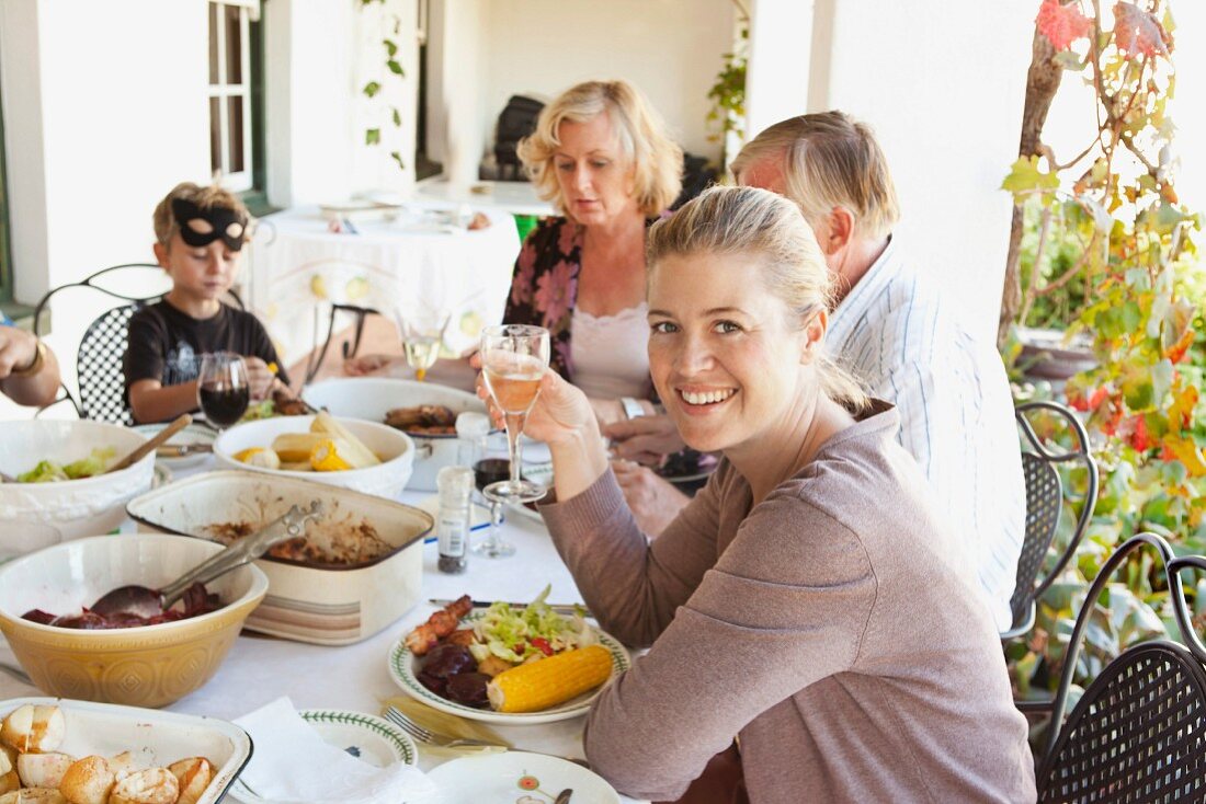 Familie isst gemeinsam vor dem Haus