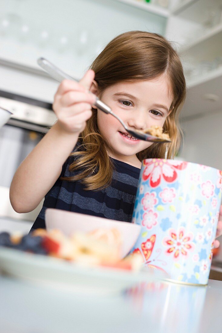 Girl putting cereals into her bowl