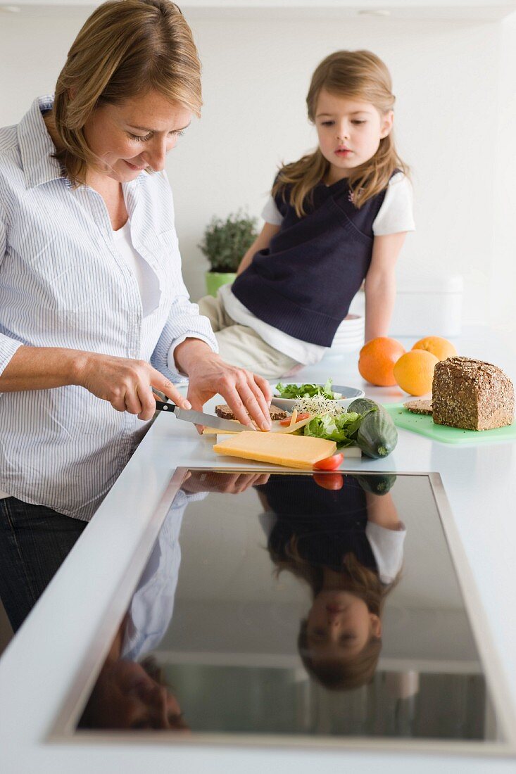 Mutter bereitet Sandwich für Tochter zu