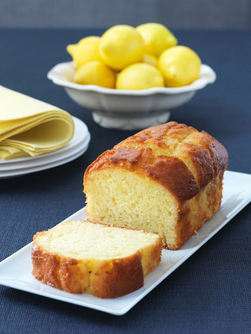 Sliced Loaf of Lemon Pound Cake with a Bowl of Lemons in Background