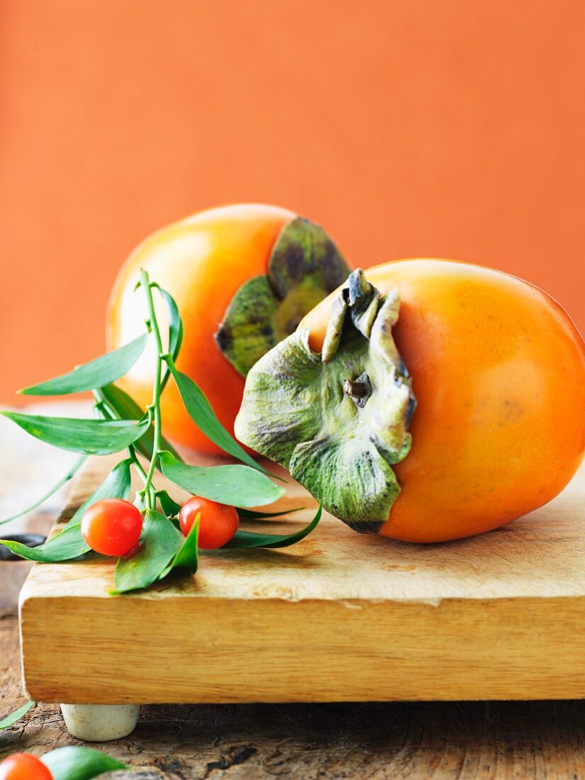 Two Persimmons on a Cutting Board