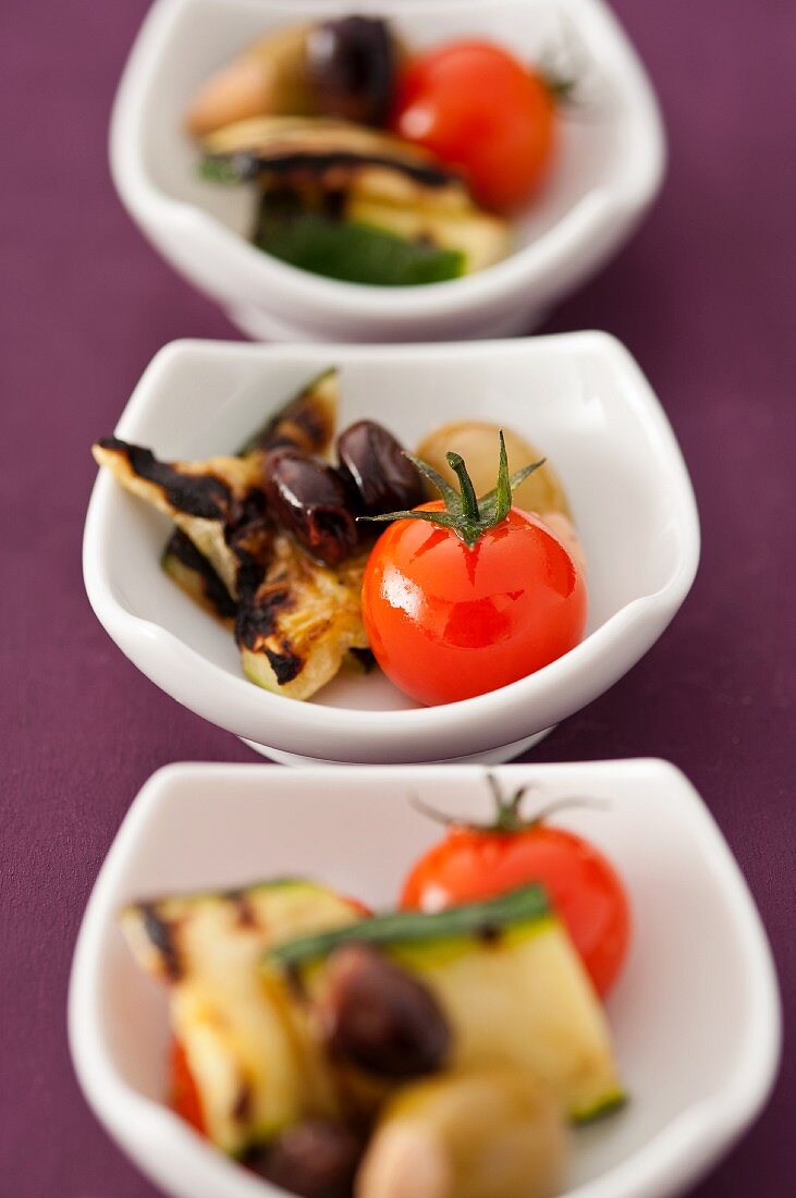 Bowls of antipasti (tomatoes, courgette and olives)