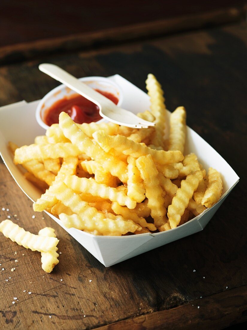 Pommes frites mit Ketchup im Pappteller